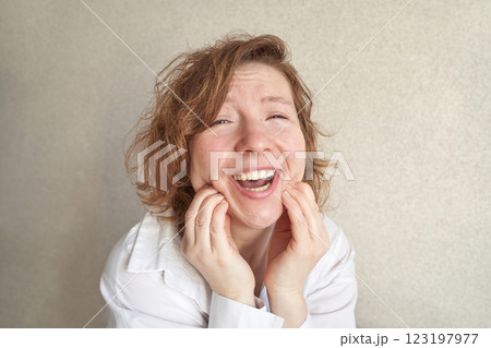 Joyful caucasian adult female expressing happiness with hands on cheeks against Joyful caucasian adult female expressing happiness with hands on cheeks against 123197977