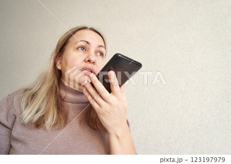 Caucasian mature female using smartphone for voice message in casual setting 123197979