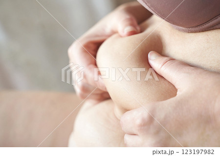 Female caucasian adult pinching belly fat close up highlighting body positivity 123197982