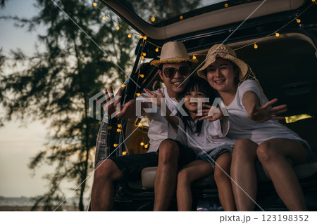 Asian family sitting back car to beach at sunset feeling funny in holidays and relaxation together. Dad, mom and daughter happy weekend travel enjoy at beach. summer vacation travel camping road trip Asian family sitting back car to beach at sunset feeling funny in holidays and relaxation together. Dad, mom and daughter happy weekend travel enjoy at beach. summer vacation travel camping road trip 123198352