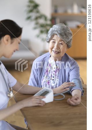 看護師に血圧を測定してもらうシニア女性 看護師に血圧を測定してもらうシニア女性 123198616