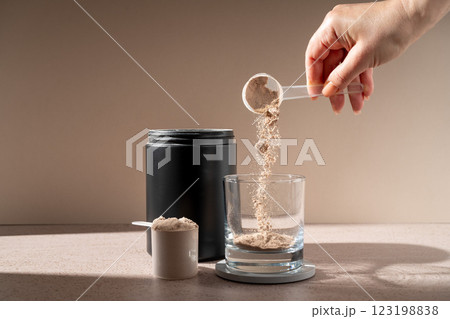 Chocolate protein powder in a scoop, food supplement 123198838