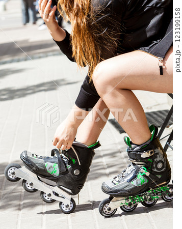 Young woman putting roller skates on 123199158