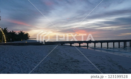 Maldives pier at sunset with pink and orange sky illuminating the ocean Maldives pier at sunset with pink and orange sky illuminating the ocean 123199528
