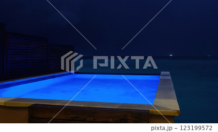 Infinity pool overlooking the ocean at night with blue lighting Infinity pool overlooking the ocean at night with blue lighting 123199572