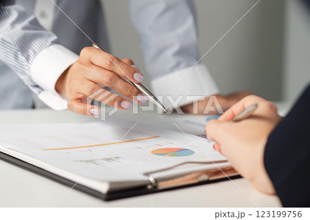 Business professionals discussing financial strategies and analyzing reports in a collaborative office environment. 123199756
