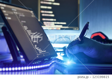 Modern programmer working on coding in futuristic workspace with blue ambient lighting and digital devices Modern programmer working on coding in futuristic workspace with blue ambient lighting and digital devices 123199815