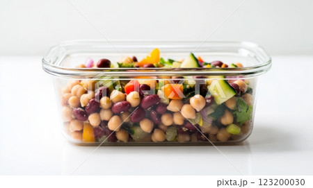 A high-protein bean salad in a minimalist glass lunchbox, featuring lentils, chickpeas, and vegetables for a balanced, healthy meal. 123200030