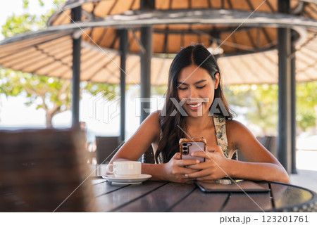 Young happy woman using phone in cafe Young happy woman using phone in cafe 123201761