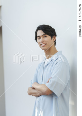 腕組みをしたカメラ目線の20代の男性　 123202020