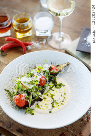 Vegan warm asparagus-broccoli salad with dill aioli, vegan cheese. Delicious healthy vegeterian food served for lunch on a table in modern gourmet cuisine restaurant 123202424