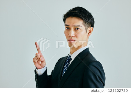 人差し指を立てる若い男性 123202720
