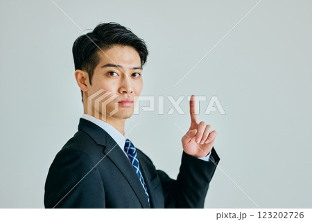 人差し指を立てる若い男性 123202726
