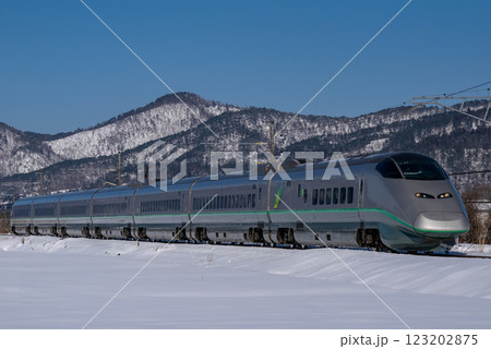 雪景色の中を走る銀色の山形新幹線つばさ 123202875