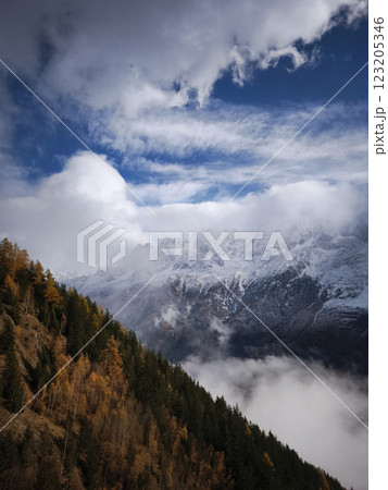 Stunning view of chamonix, france, with snow covered mountains and a vibrant autumn forest under a dynamic cloudy sky Stunning view of chamonix, france, with snow covered mountains and a vibrant autumn forest under a dynamic cloudy sky 123205346