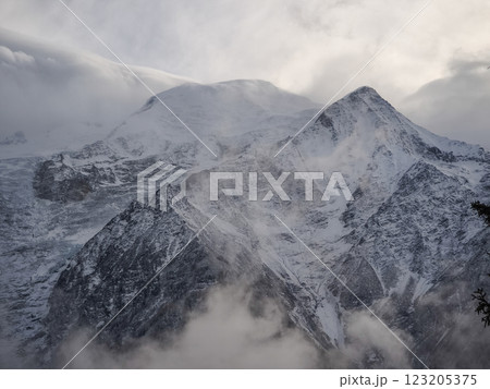 Snowy mountain peaks rising through misty clouds in chamonix, dramatic alpine landscape under winter's soft light Snowy mountain peaks rising through misty clouds in chamonix, dramatic alpine landscape under winter's soft light 123205375