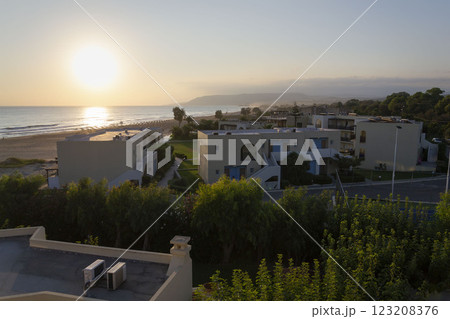 Blue and white tourist apartments on the beachfront during sunrise in Crete, Greece, sunny summer day 123208376