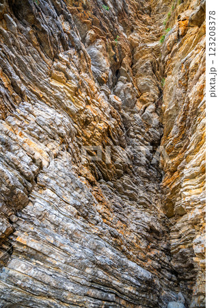 Layered rock texture in Budva, Montenegro. Sedimentary rocks with rugged surface of gray and brown. Natural formation of layers and cracks, geological structure. 123208378