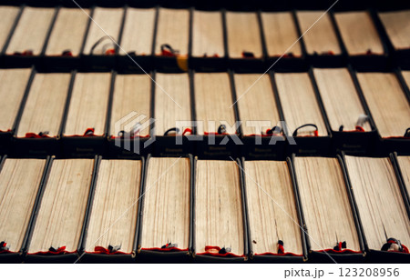 A collection of aged books stacked uniformly with visible bookmarks. The warm, nostalgic color 123208956