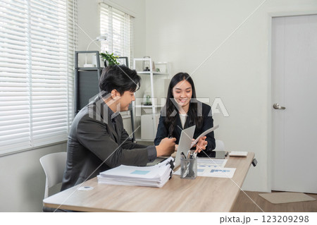 Diverse business professionals collaborating on financial reports and analysis in a modern office. 123209298