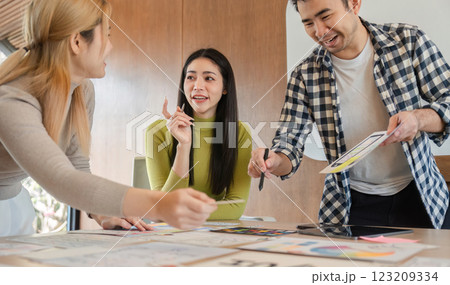 Diverse design team sharing ideas and collaborating on project at office table. 123209334