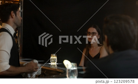 Woman and friends special in drink gin fizz with barman wiping glass. Vinosity. 123209578