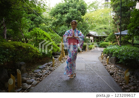 Woman in Floral Kimono Walking Through Japanese Garden  123209617