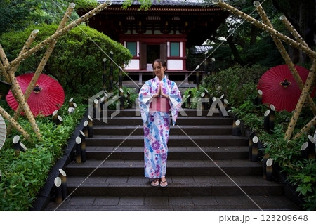 Woman in Kimono Meditating on Steps of Japanese Temple  123209648