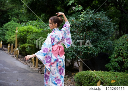 Elegant Woman in Kimono Striking a Graceful Pose Outdoors  123209653