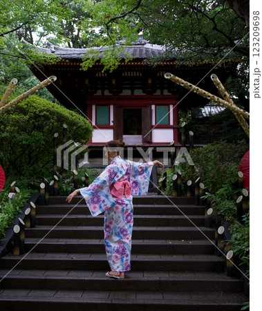 Woman in Kimono Striking Elegant Pose on Temple Steps Woman in Kimono Striking Elegant Pose on Temple Steps 123209698