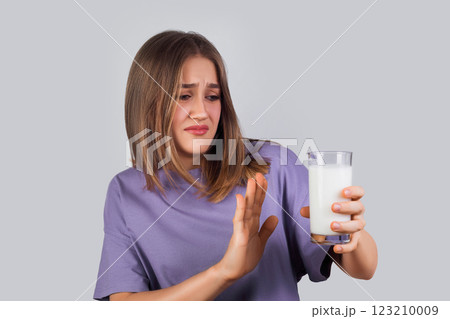 Portrait of a girl hate milk. dislike, disgusting drink doesn't want drinking milk isolated on light background. Portrait of a girl hate milk. dislike, disgusting drink doesn't want drinking milk isolated on light background. 123210009