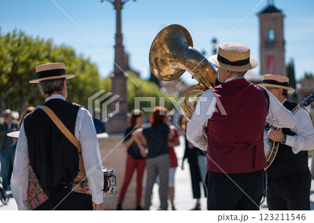 street musicians with brass instruments perform lively tunes in a sunlit plaza during a vibrant outdoor gathering in Spain street musicians with brass instruments perform lively tunes in a sunlit plaza during a vibrant outdoor gathering in Spain 123211546