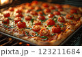 Californiastyle pizza with pizza cheese, tomatoes, and basil baking in the oven 123211684