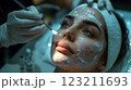 Woman receiving facial treatment at salon, enhancing jawline and eyelashes 123211693