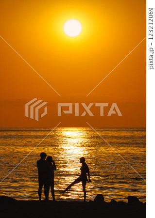 Sunrise view from Malaga seaside city in Andalusia, Spain, Europe. Silhouetted figures on a beach at sunrise, enjoying the golden hour. Sunrise view from Malaga seaside city in Andalusia, Spain, Europe. Silhouetted figures on a beach at sunrise, enjoying the golden hour. 123212069