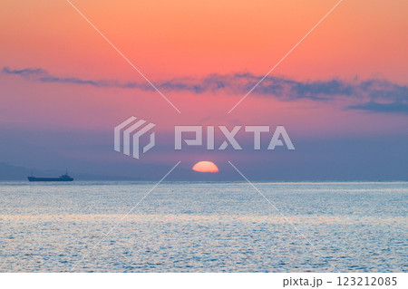 Sunrise view from Malaga seaside city in Andalusia, Spain, Europe. Serene sunrise over calm ocean waters, a lone vessel on the horizon. 123212085