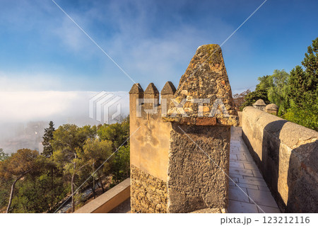 Castle of Gibralfaro in Malaga city at Andalusia, Spain, Europe. Ancient stone wall overlooking a misty valley. A serene, historical view. Castle of Gibralfaro in Malaga city at Andalusia, Spain, Europe. Ancient stone wall overlooking a misty valley. A serene, historical view. 123212116
