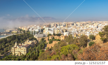 Malaga, seaside city in Andalusia, Spain, Europe. Panoramic view of a city nestled amongst hills and mountains under a clear blue sky. 123212137