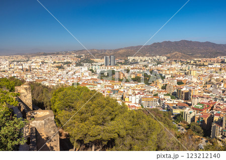 Malaga, seaside city in Andalusia, Spain, Europe. Panoramic view of a city nestled in a valley, surrounded by mountains under a clear blue sky. 123212140