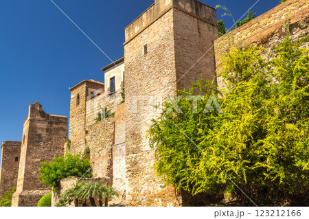 Alcazaba, palace and fortification in Malaga city at Andalusia, Spain, Europe. Ancient stone walls and towers bask in the sun, lush greenery adding a vibrant contrast. 123212166