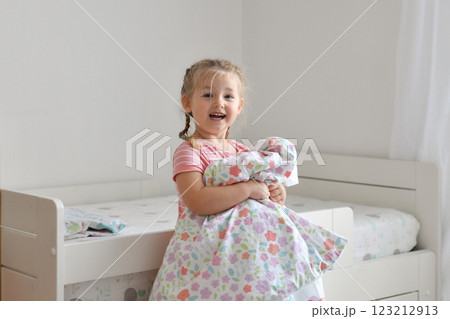 A girl makes a bed in the childrens room 123212913