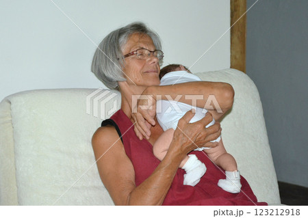 A gray-haired grandmother holding a newborn baby 123212918