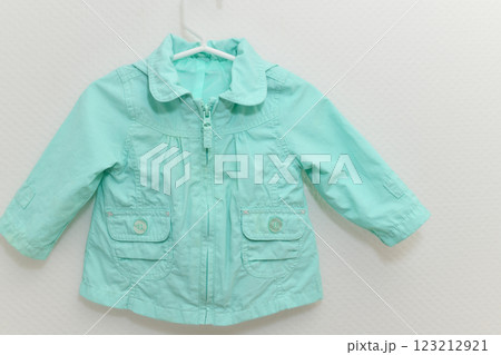 Menthol colored jacket hanging on hanger on white background Menthol colored jacket hanging on hanger on white background 123212921