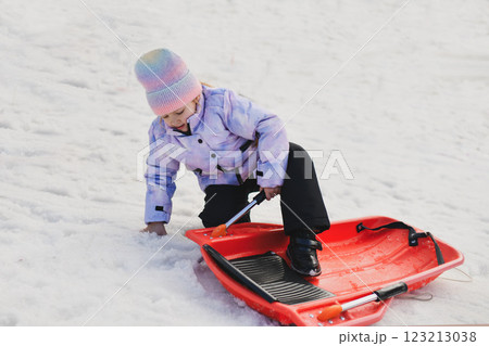 A girl with red snow bob sledding in the snow 123213038
