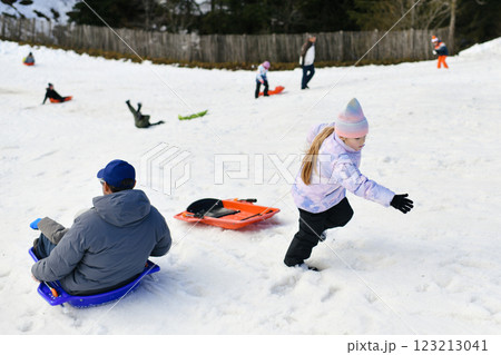 A father with child sledding in the snow 123213041