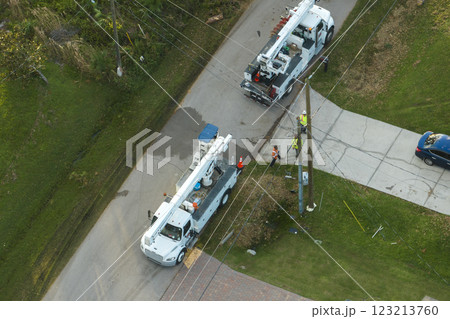 Electrical service company restoring power repairing damaged power lines after hurricane Ian in Florida suburban area 123213760