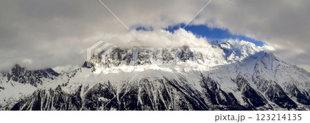 Breathtaking aerial view of Mont Blanc mountain peak covered with shiny snow, ice and glaciers under blue sky with puffy white clouds on the French side of Alps on a clear cold sunny winter day 123214135