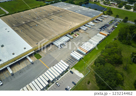 Aerial view of large commercial loading bay with many delivery trucks unloading and uploading retail goods for nationwide distribution. Global economy concept Aerial view of large commercial loading bay with many delivery trucks unloading and uploading retail goods for nationwide distribution. Global economy concept 123214462