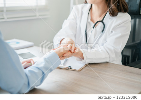 A healthcare professional consulting with a patient in a modern medical office, emphasizing care and communication. A healthcare professional consulting with a patient in a modern medical office, emphasizing care and communication. 123215080