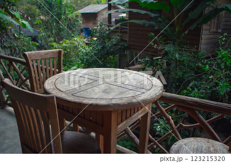 Serene outdoor dining area with wooden furniture Serene outdoor dining area with wooden furniture 123215320